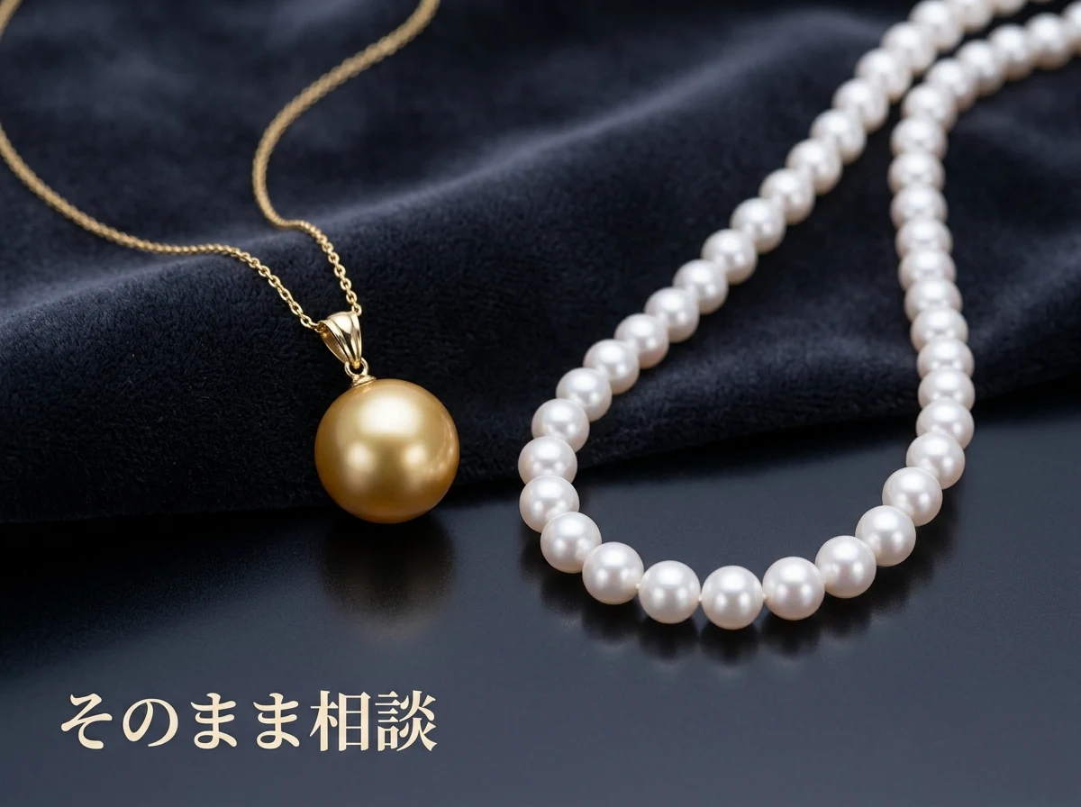 布の上に置かれた金色の真珠のペンダントとアコヤ真珠のネックレス