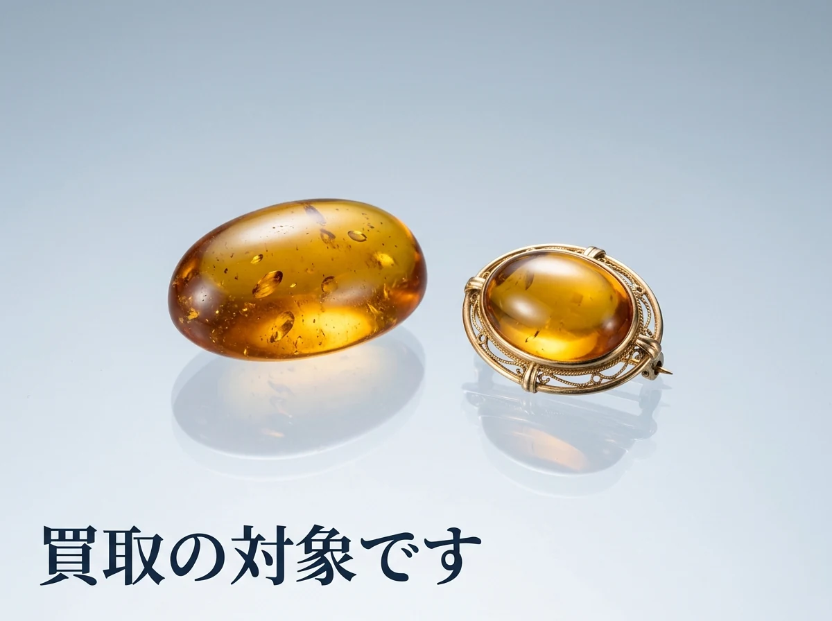 琥珀のルースとブローチを光沢のある面に置いた写真