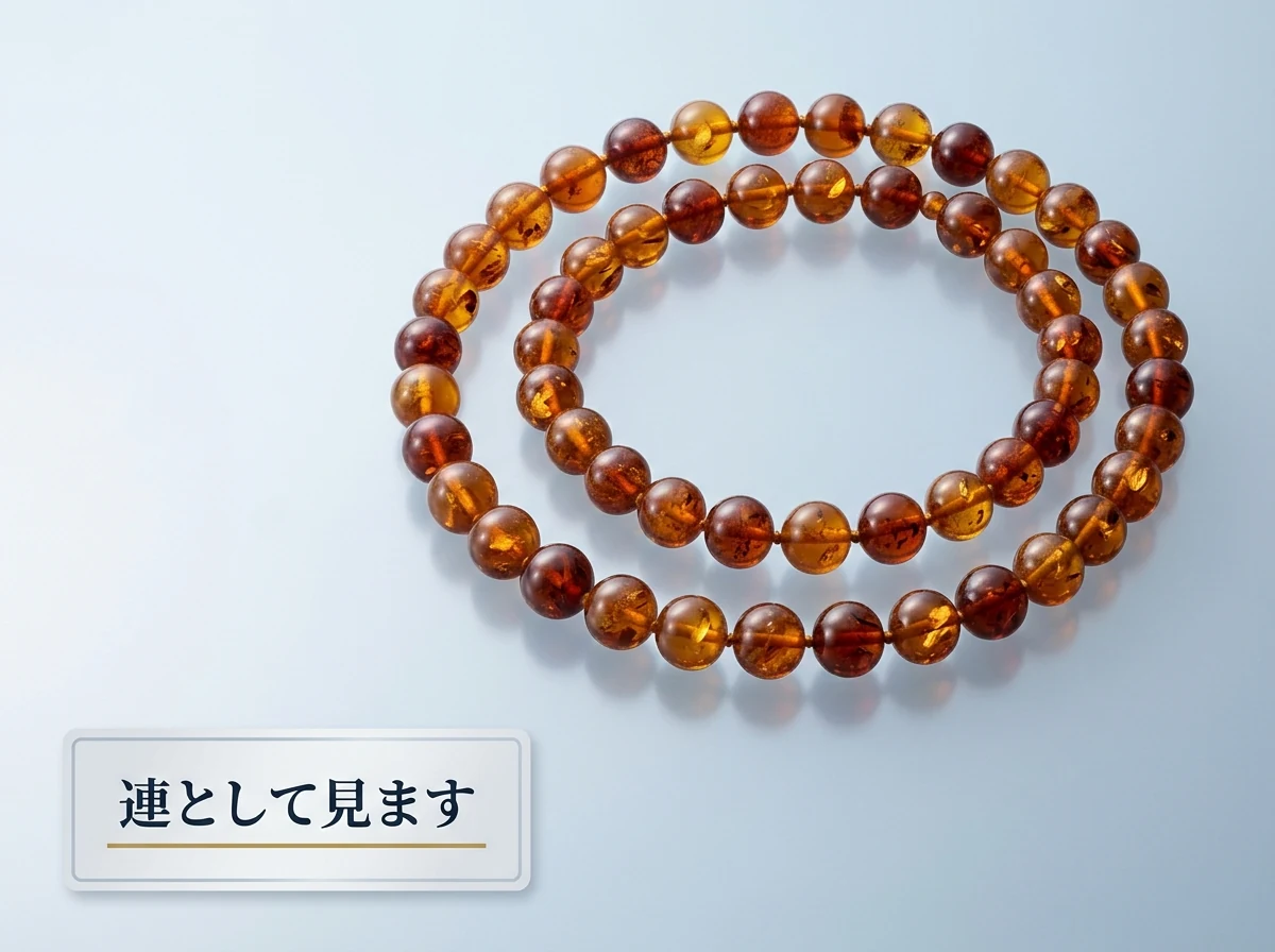 全体として赤みのそろった琥珀のネックレスを輪にして置いた写真