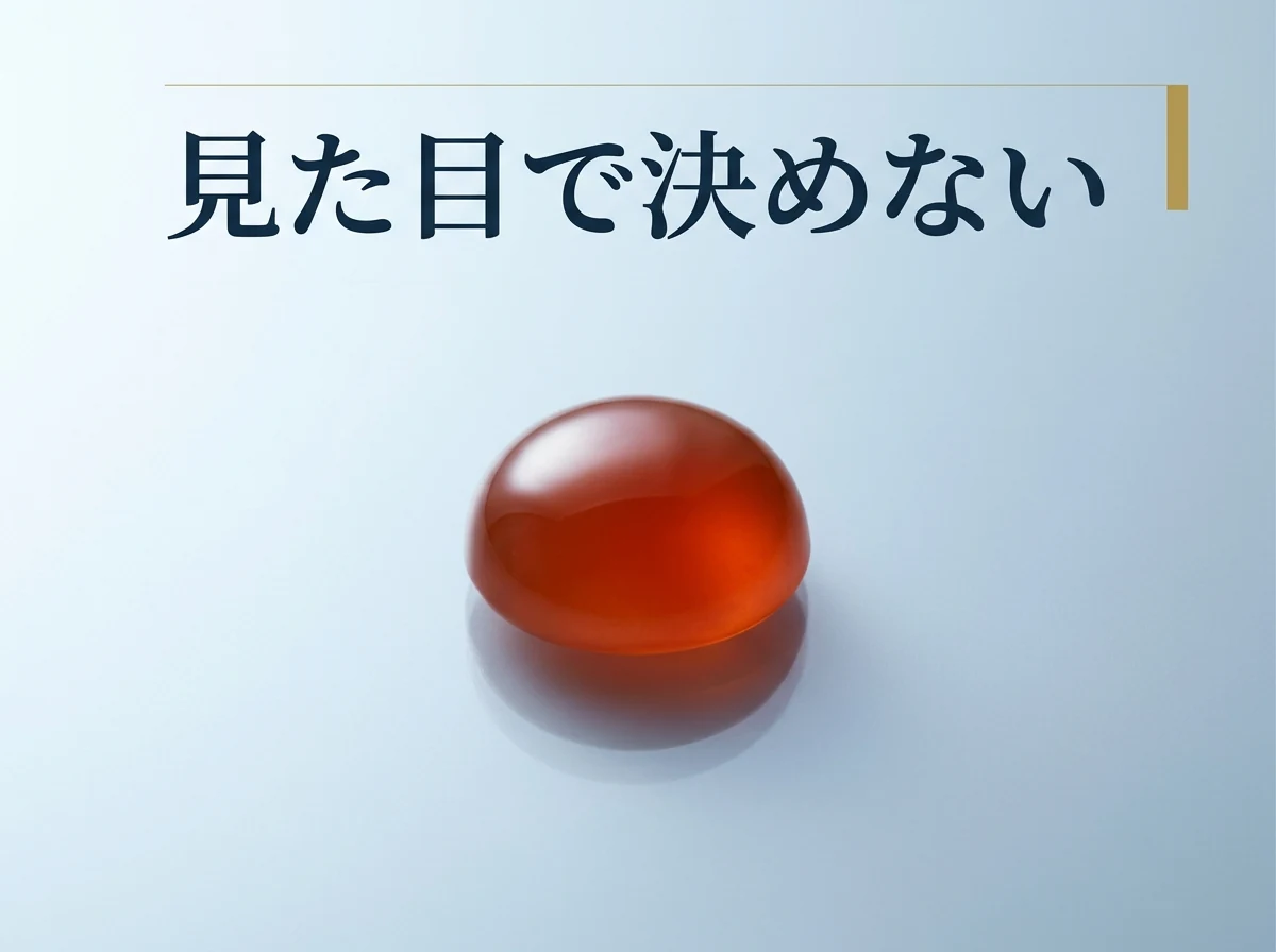光沢のある面に置いた、カーネリアンのカボション1石の写真
