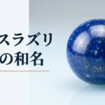 光沢のある面に置いた、金色の粒が散る濃い青のラピスラズリを磨いた球の写真